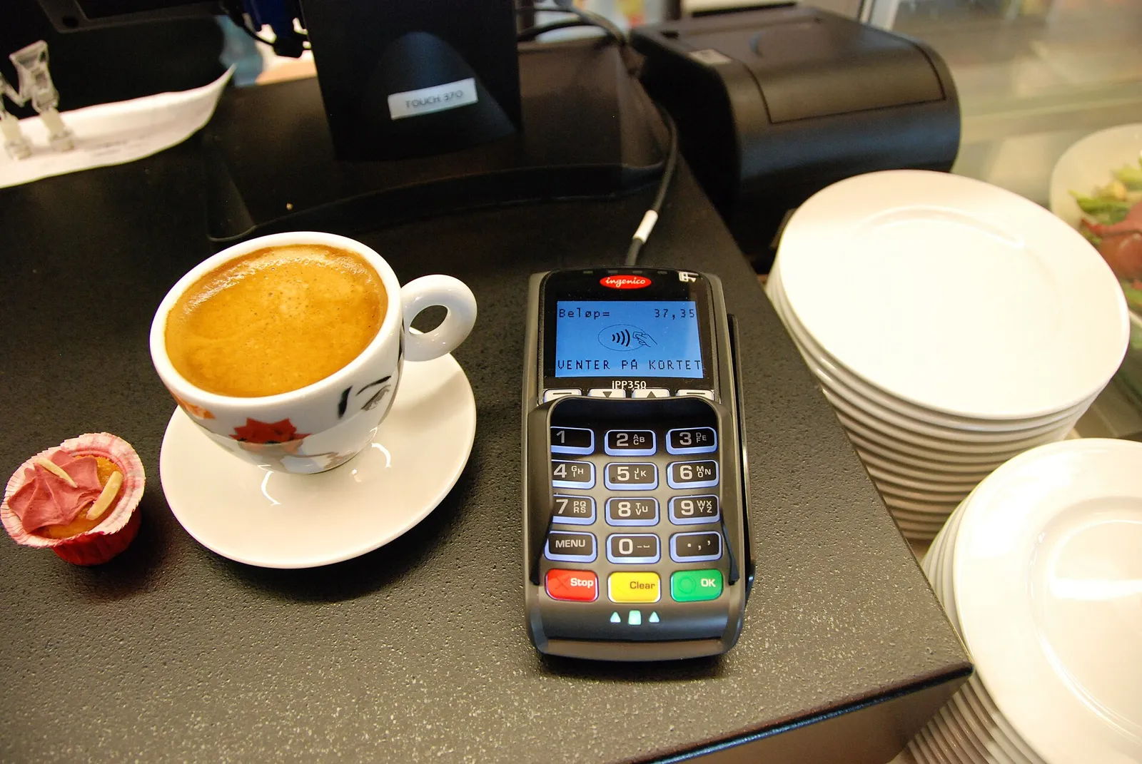 Mobiles Bezahlen per Smartphone an einem Kartenterminal (Symbolbild)